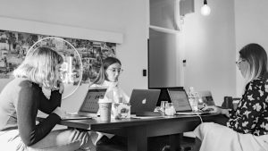 A team sit around laptops, working on Digital marketing campaigns which are vital for small businesses